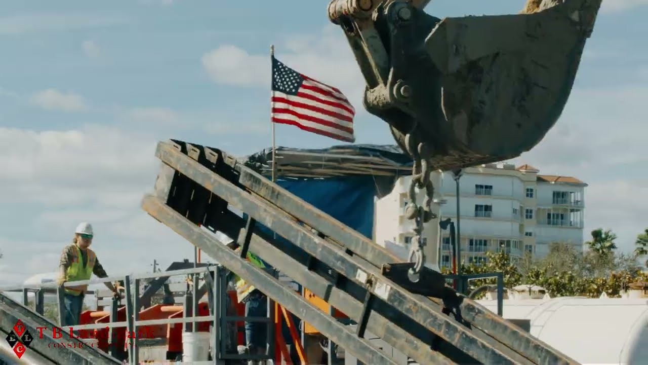 TB Landmark excavator at work beside an American flag on a jobsite